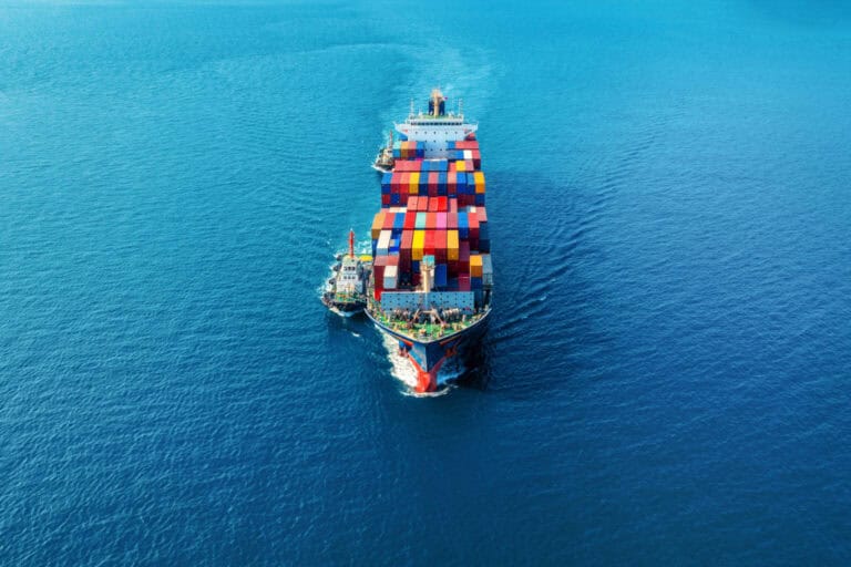 Vista aérea de un barco de carga transportando contenedores en el mar, representando la logística marítima de CPS República Dominicana