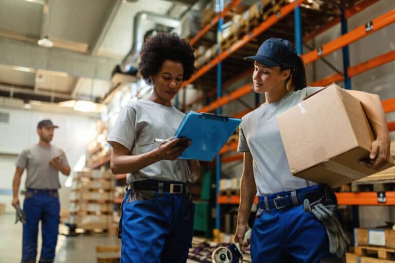 Trabajadoras del almacén de CPS República Dominicana revisando la lista de envíos